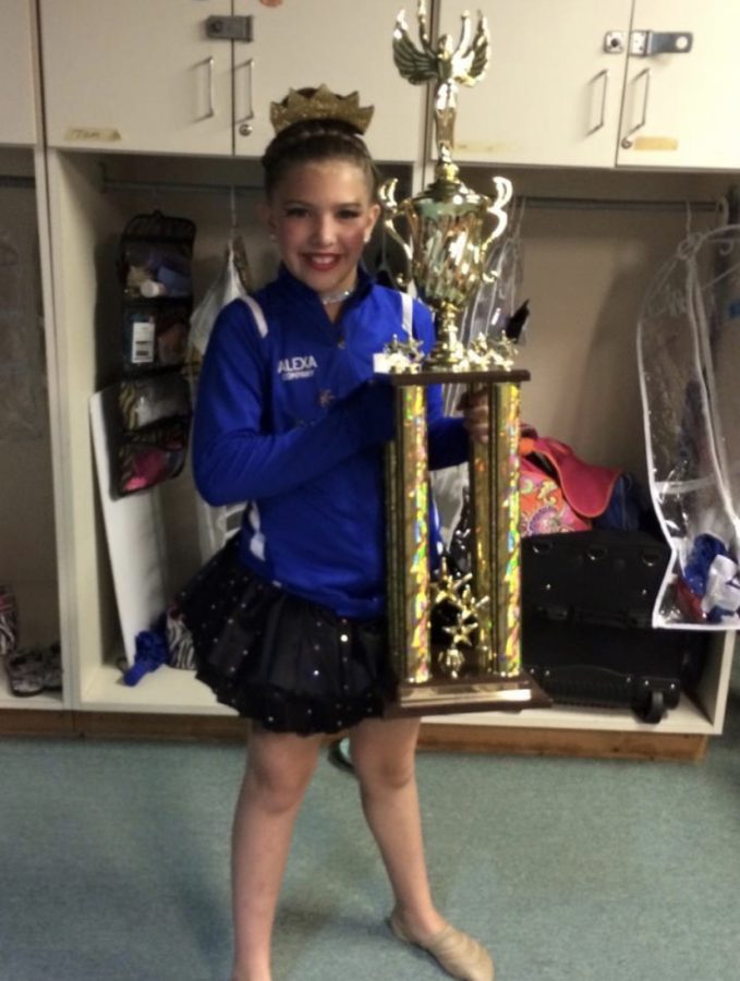 Ten-year-old Schneider poses with the championship trophy her team won at the junior nationals competition in Branson.  This was one of many awards Schneider has received throughout her dance career.