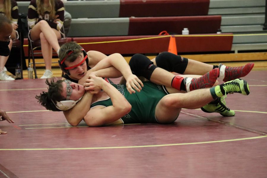 Sophomore Dereck Wacker attempts to pin opponent at the conference meet last year. Wackers record last season was 33-11.