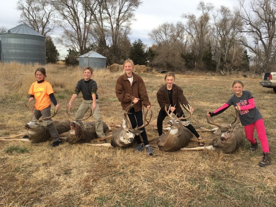 Sophomore Bella Tederman (second from right) poses for a picture with her deer and family. Tederman hunts with her siblings and cousins every year. 