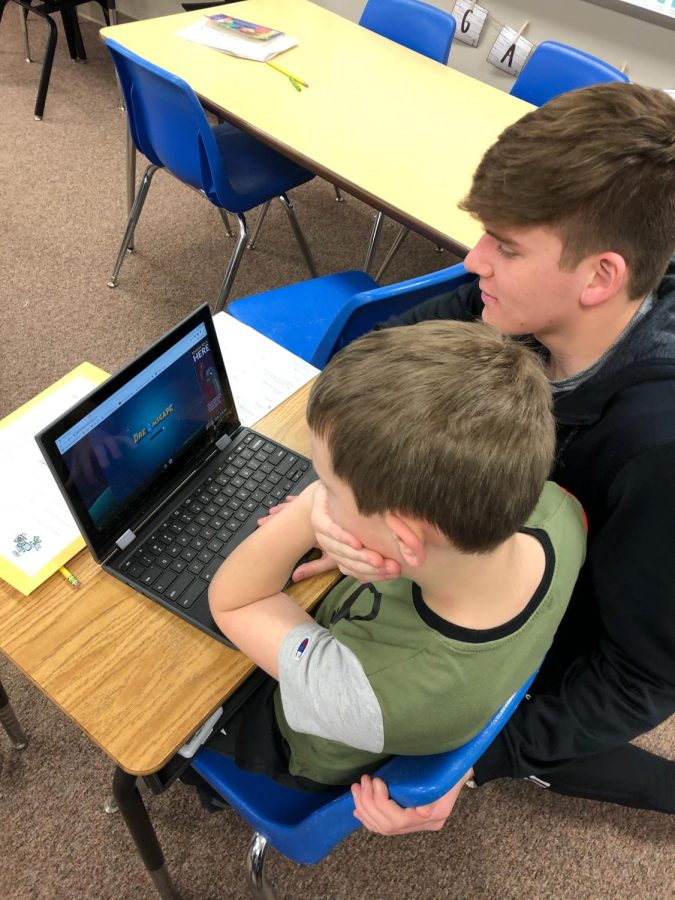 Senior Isaiah Daniell assists a fourth grader at school while he uses his chromebook. Daniell started his internship on ___.