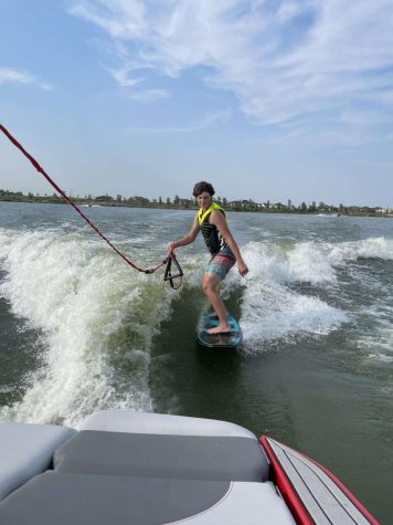 Junior Zach Kennedy wake surfs on Lake Big Sandy. Kennedy would also wakeboard and tube on the lake. 
