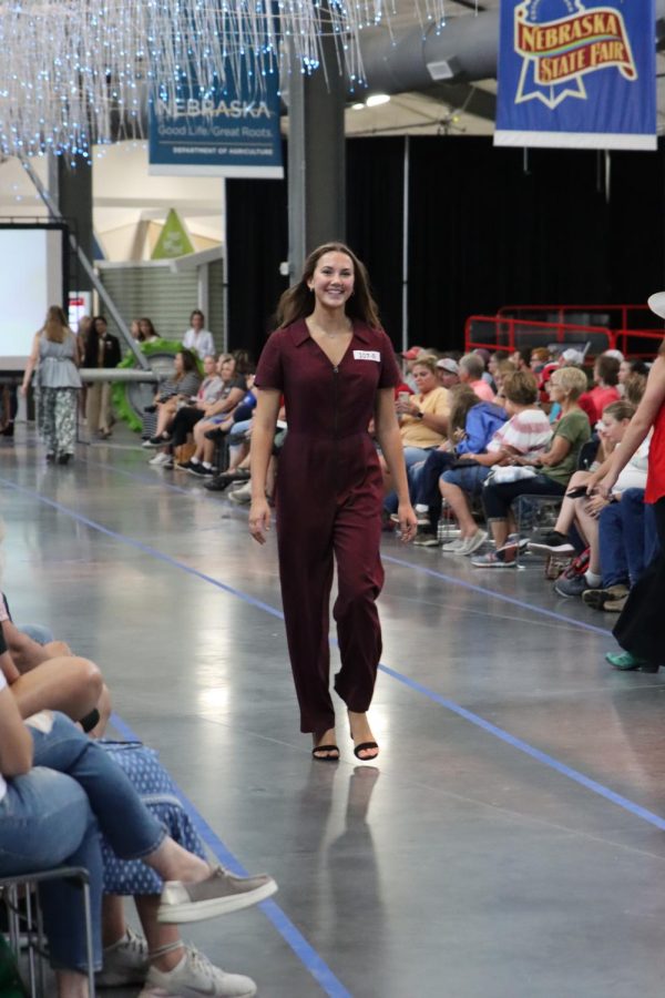 Junior Maura Tichota walks down the runway at the Nebraska State Fair. This year Tichota created a burgundy jumpsuit and upcycled some mens dress shirts into a dress for the fair. 