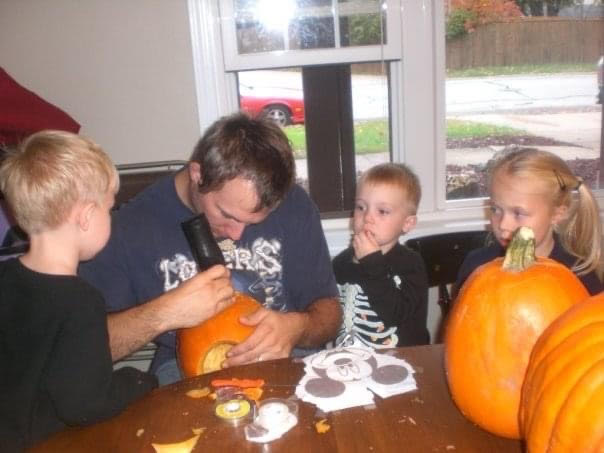 Social studies teacher Dan Krajicek carves pumpkins with his kids Zach, Drew and Heidi in 2010. Even though the Krajiceks are busy with activities, they still carve pumpkins every October.