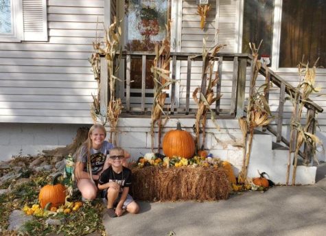 After they finish decorating their house freshman Adie Gale poses with her brother Colton. The Gale family decorates their house with pumpkins, corn stalks, scarecrows and a hay bale. 