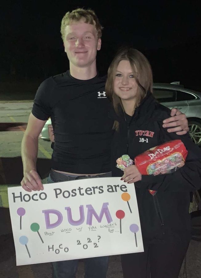Sophomores AJ Arensberg and Libby Winn pose with their poster and Dum-Dums.  Arensberg presented the hoco-prosal after a football game.