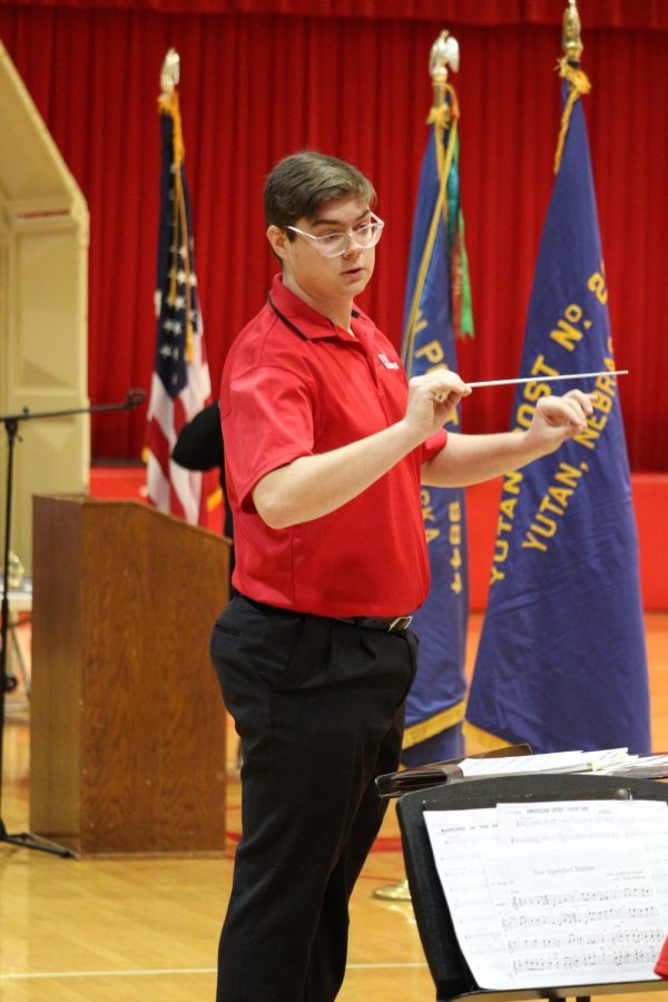 Band director Hunter Holoubek conducts the high school band. The band played three songs at the program: Star Spangled Banner, American Spirit Overture, and Marches of the Armed Forces.