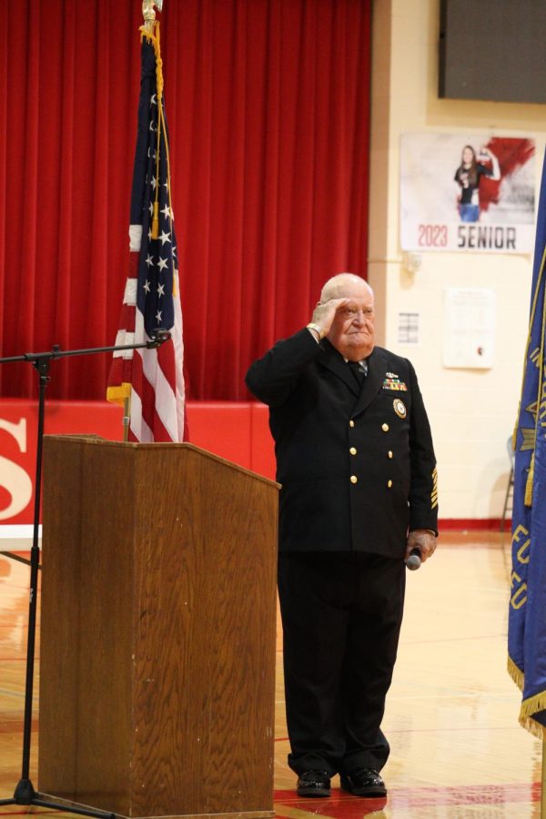 Hank Sauer raises his hand in salute as Taps is played.  Sauer has been the lead organizer of Yutans Veterans Day program for close to 30 years.
