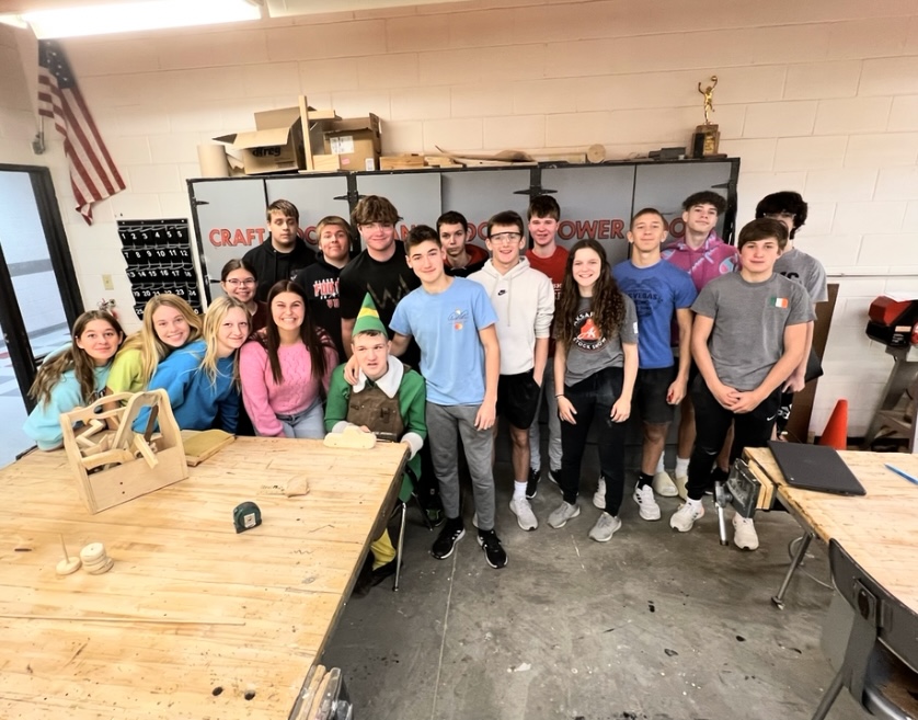 Junior Ollie Egr and his classmate helpers take a picture working in the shop to build wooden toy cars. With the help of classmates, Egr handcrafted wooden vehicles for kids in need to open on Christmas morning.
