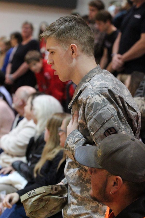 Junior Ollie Egr stands up as the anthem for the Army is played. Last spring, Egr was sworn in to the Nebraska Army National Guard as Honorary Command Sergeant Major Egr. 