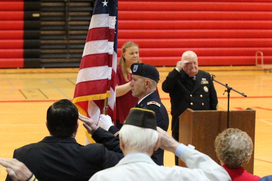 The crowd stands in respect as the American flag is carried out of the gym.  The  posting and retiring of the colors were done by American Legion Post #262, VFW Post #9844 and Sons of American Legion Post #262.