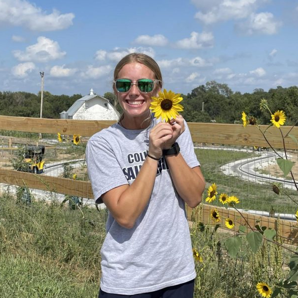 Senior Shaylynn Campbell poses with a sunflower at Vala's Pumpkin Patch. Campbell enjoys the apple orchard the most. "I love getting to go somewhere with my family to celebrate the fall," Campbell said. 