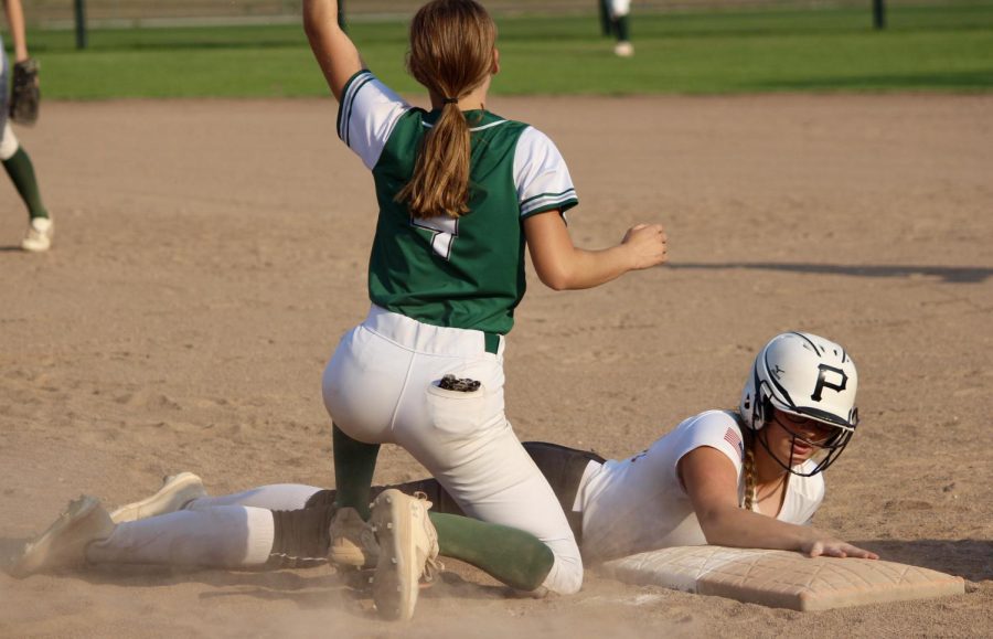 Junior Andi Nelson slides back into first base during a softball game against Syracuse. Nelson fought through many injuries throughout her high school softball career.
