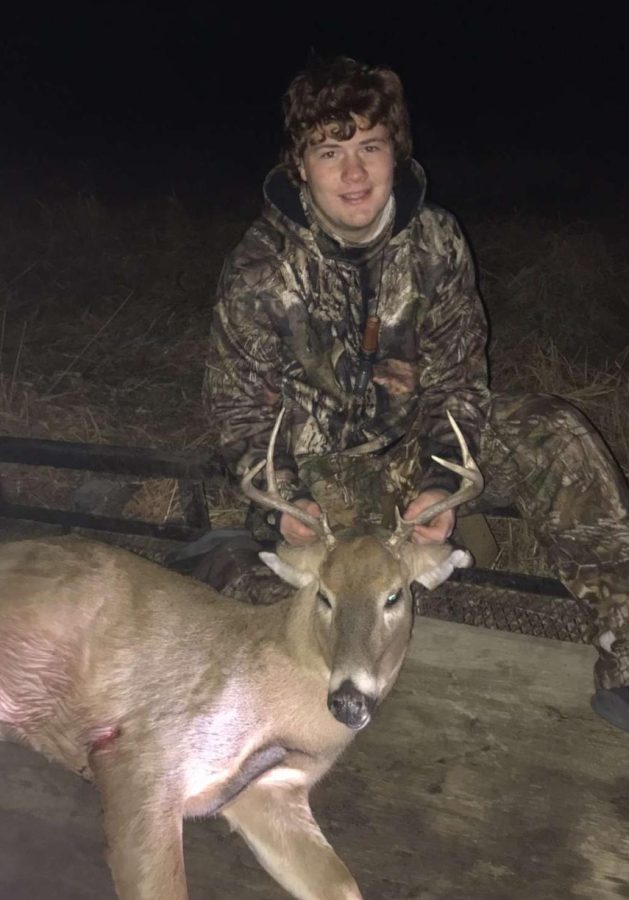 Sophomore Austin McIntyre poses for a picture with a deer he killed while hunting. McIntyre has been hunting since he could walk.