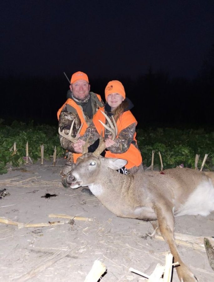 Junior Emma Scheuler and her dad pose with a deer they killed. Scheuler has been hunting with her family for 6 years.