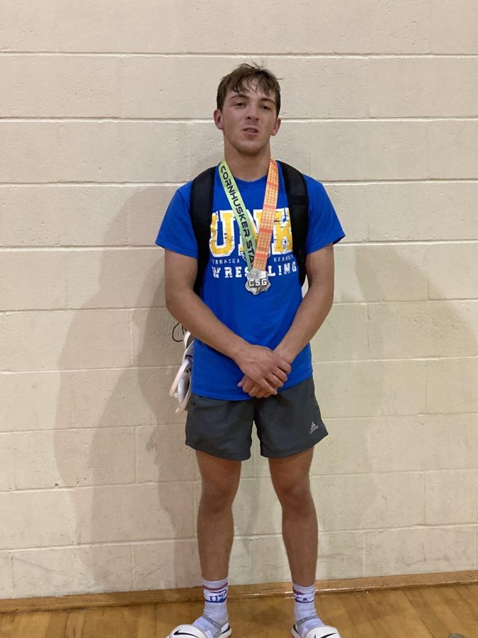 Senior Trevin Arlt poses with a medal from a tournament during the summer. Coming into his last season, Arlt is ranked fifth in Class C at 132 pound weight class. 