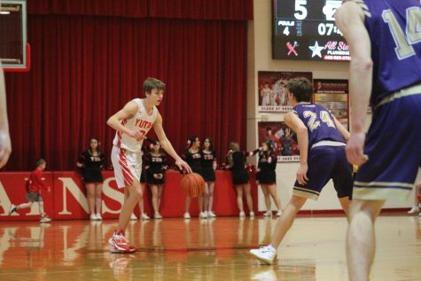 Nolan Timm dribbles the ball up the court against a Louisville defender in the 2021-22 season. Timm has been starting point guard for the past two years.