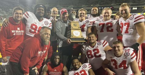 Colton Feist (82) and other  Husker defensive lineman pose with the Heroes Game trophy. The trophy is awarded to the winner of the annual Black Friday game between Nebraska and Iowa.