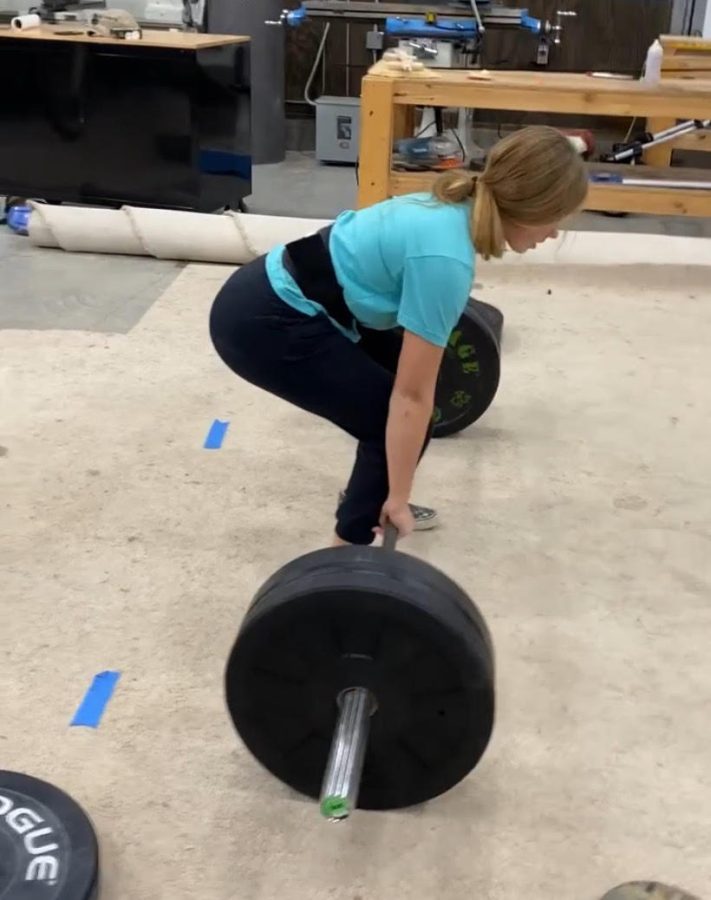 Junior Bella Tederman lifting a dead lift in her garage. Tederman lifts five times a week and sometimes more.