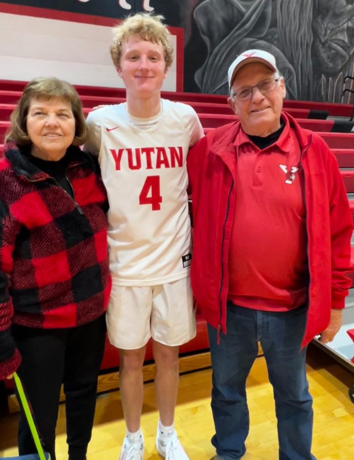 After a basketball game, sophomore AJ Arensberg smiles for a picture with his grandparents. 