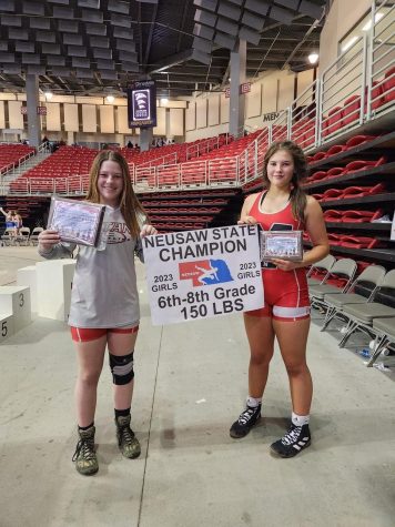 Eighth graders Amalea Vaughn-Lantzer and Ella Henkel pose for a picture with their awards after wrestling at NEUSA State in Grand Island. Henkel placed first and Vaughn-Lantzer placed third.