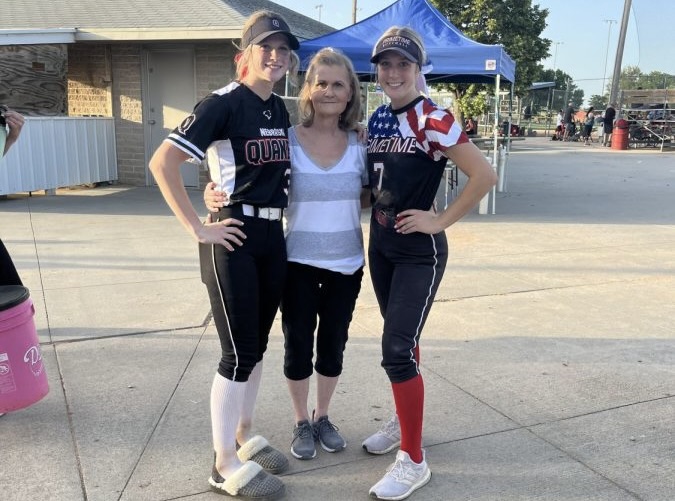 Seniors Emma Abraham and Laycee Josoff pose for a picture with their grandma, Jan Wortman, at a softball tournament. Wortman attended and supported her grandchildrens sporting event as often as she could. 