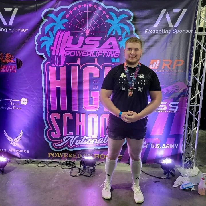 At powerlifting nationals, senior Will Peterson poses for a picture after winning a national title. Peterson won nationals just a month after earning the state title in March. 