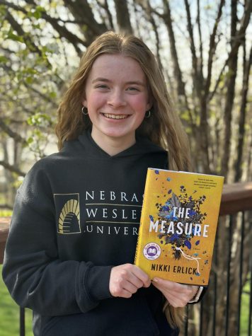 Freshman Delaney Shield poses with the book, The Measure. This book was a group read in Modern Literature. 
