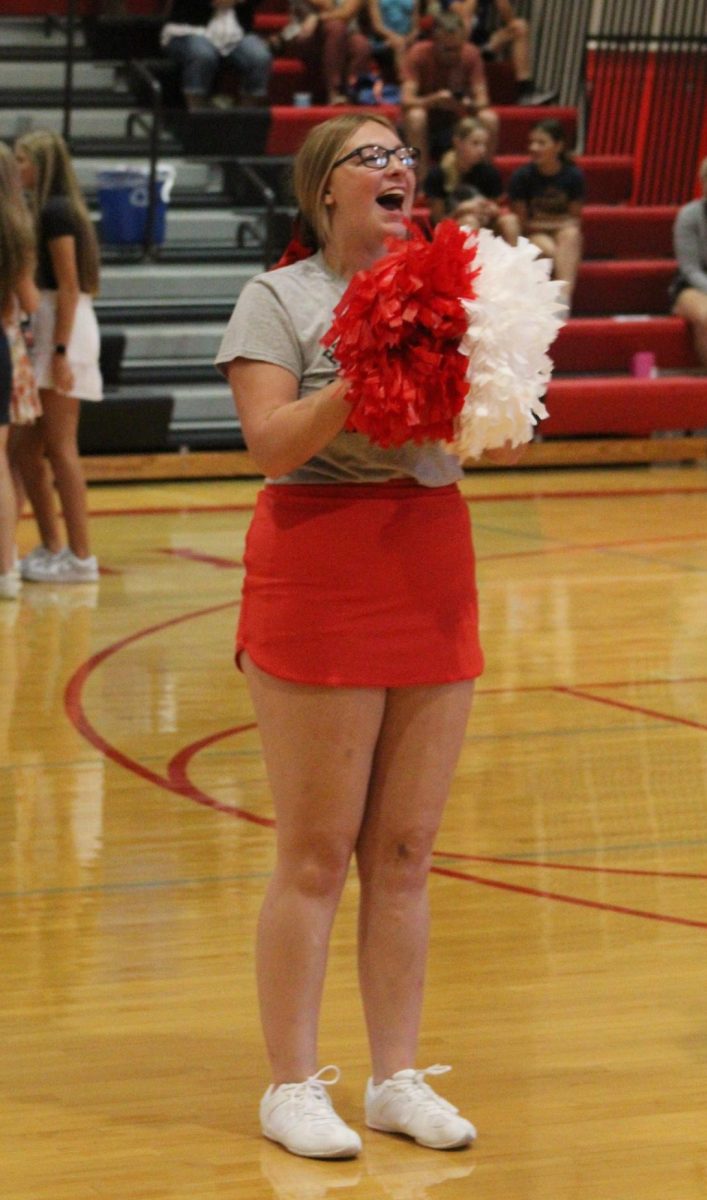 Senior Andi Nelson leads the cheerleaders in a cheer during a volleyball timeout. Nelson is one of three other captains. 
