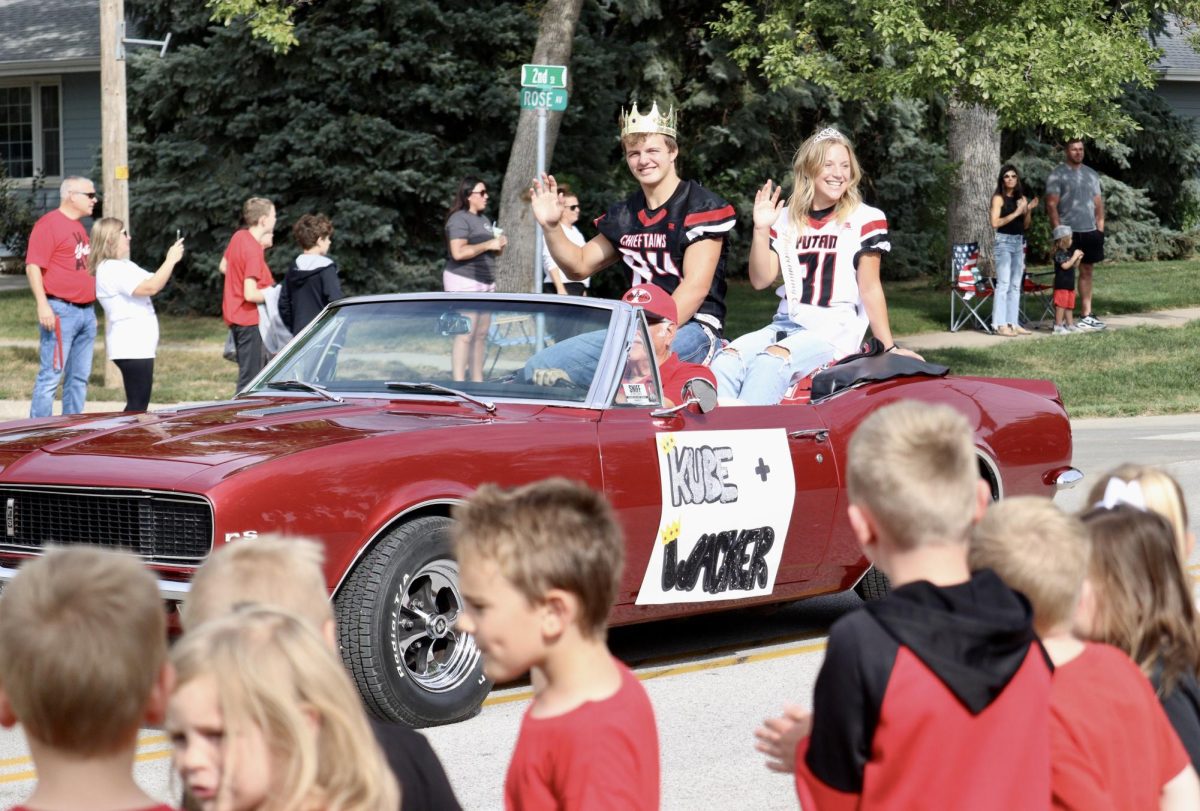 Senior royalty candidates Derek Wacker and Haley Kube wave to the elementary students during homecoming parade. Wacker and Kube drove in a 1967 Camaro belonging to former teacher Warren Mommsen. “The homecoming parade was truly an unforgettable experience. I got to see all the elementary kids looking up to Derek and me in a cool, red Camaro,” Kube said.