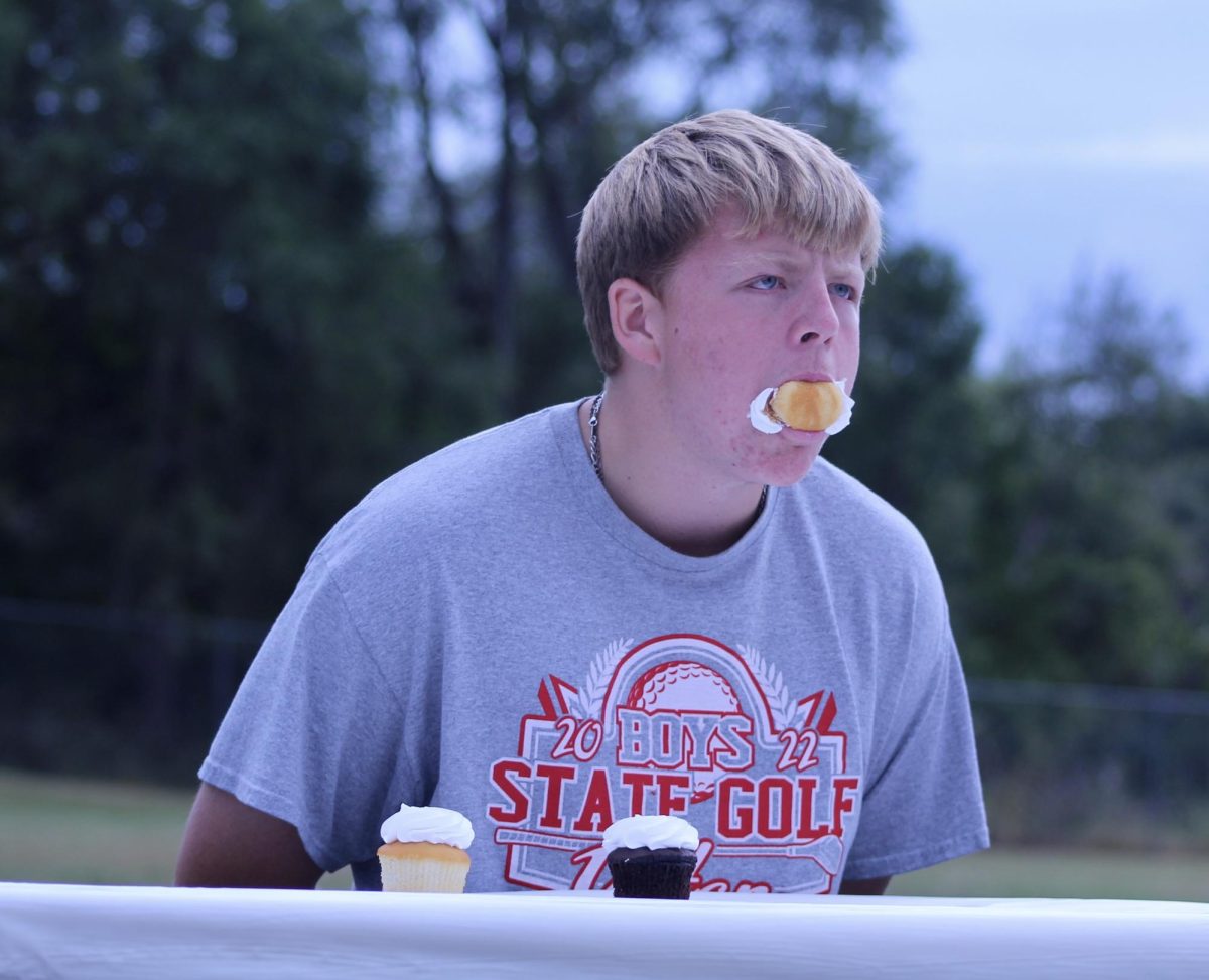 Senior Creek Kennedy stuffs his face during the cupcake eating contest. Kennedy has participated in the contest since he was in seventh grade. “I do the contest every year because I get free cupcakes,” Kennedy said.