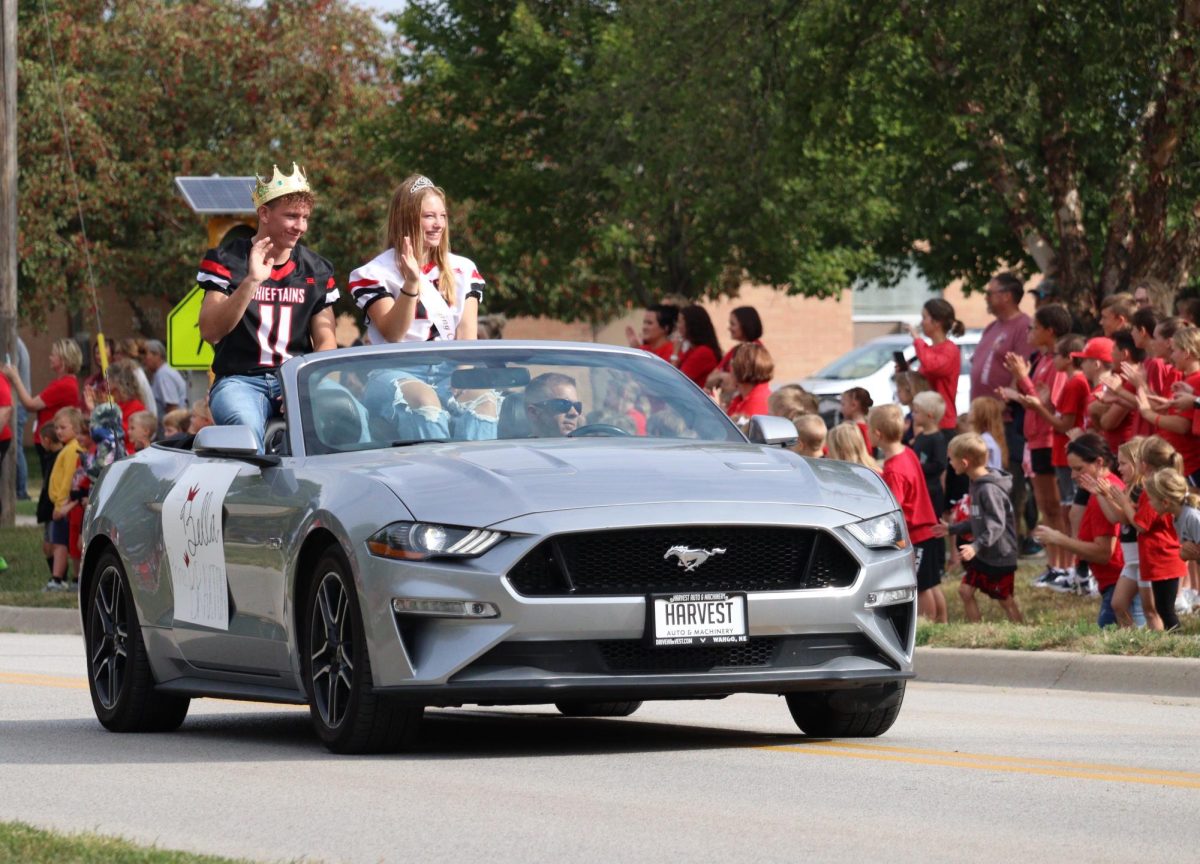 Senior royalty candidates Bella Tederman and Braxton Wentowrth wave to elementary students during the annual homecoming parade. The parade route was flipped this year, starting downtown and ending at the high school. “It was cool being in the parade and seeing all the little kids because it made me remember when I was the kid watching the homecoming court pass by,” Tederman said.