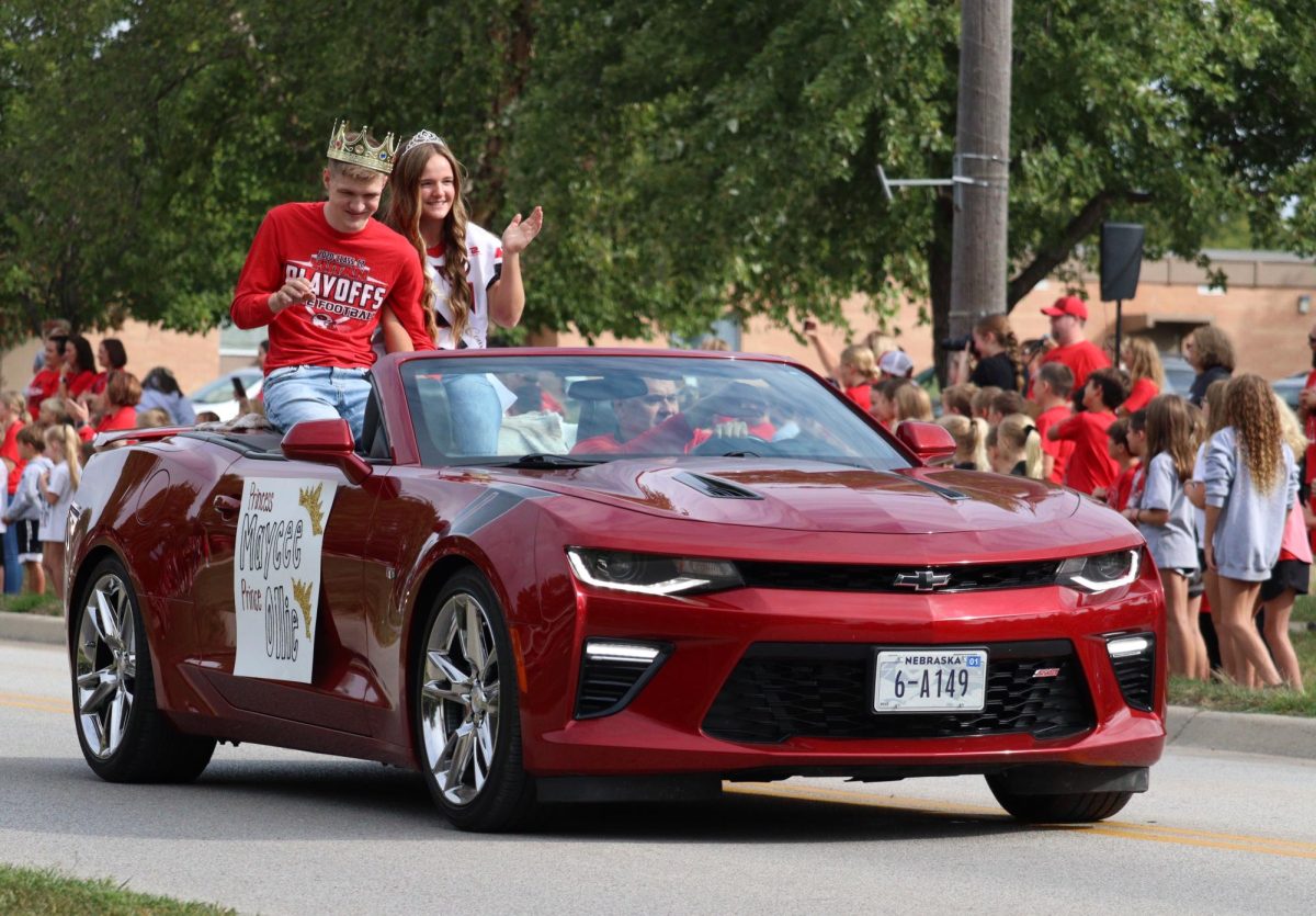 During the homecoming parade, senior royalty candidates Ollie Egr and Maycee Hays wave to the crowd. This year, Egr won homecoming king. “My uncle Danny was king, so I was king too. So there were other kings in the family,” Egr said.
