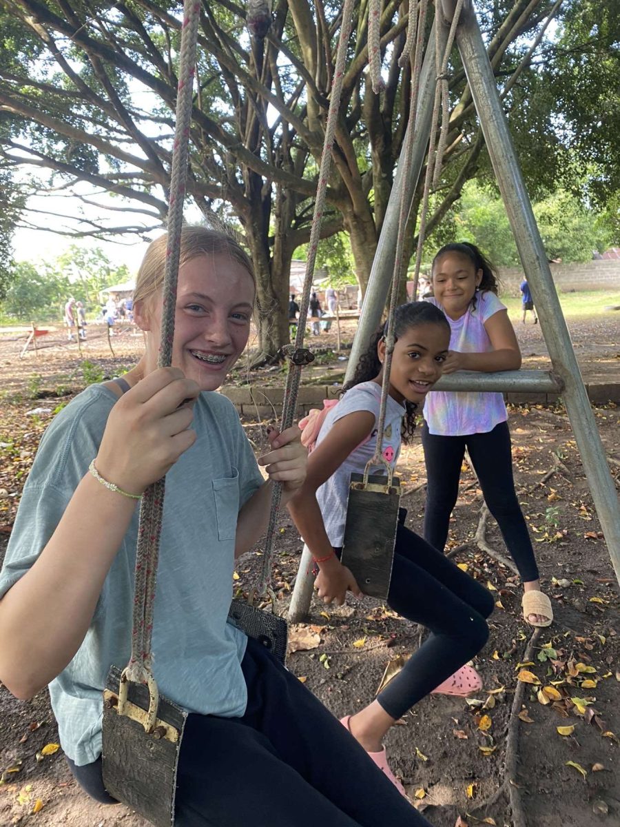 Gabi Tederman poses for a photo on the swings with kids in the Dominican Republic. Besides playing sports with the kids, they also played a bunch of games.
