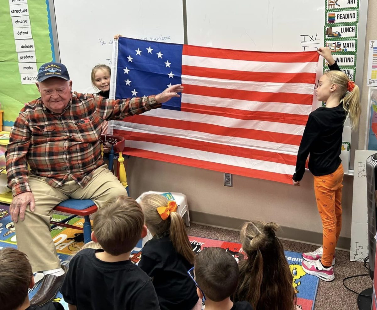Local veteran Hank Sauer explains the meaning of each of the flags colors to the first grade class. Sauer has been doing this lesson for the past eight years. 