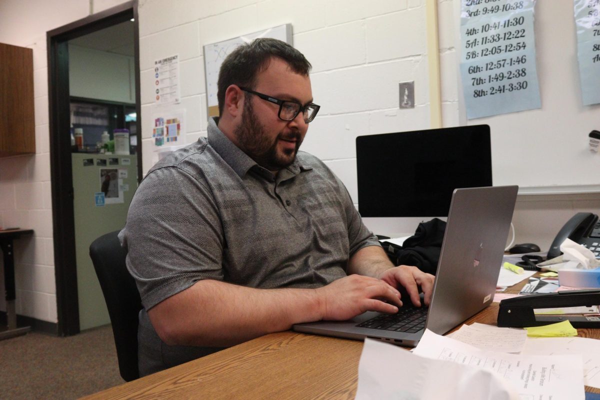 Special education teacher Michael Swanson sits at his desk planning for the day. Swanson supervises one special education study hall and spends the rest of his day supporting students in the classroom.