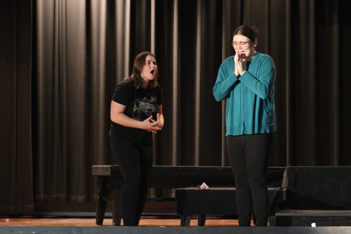 Senior Hailey Drews and sophomore Bella Sliva stare in shock as three of their friends jump off the stage. At the end of the play, Drewss character was the only one left on stage.