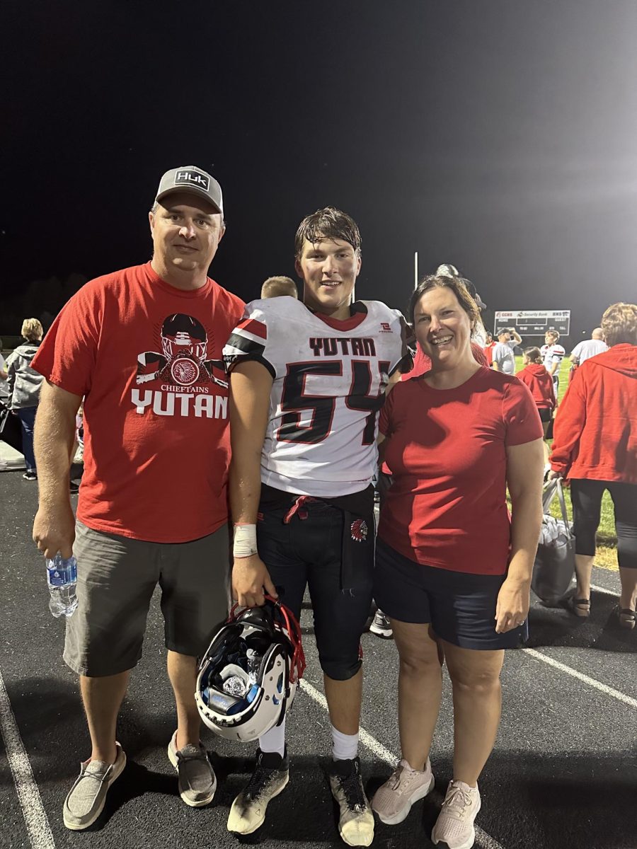 Senior Zach Kennedy takes a picture with his parents, Scott and Lynnette Kennedy, after an away football game. Zach was the starting varsity center for the Chieftains.