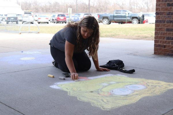 Eighth-grader Norah Jones helps chalk the sidewalk during a Random Acts of Kindness Club activity. The RAK Club has done several other projects this year to brighten students days.