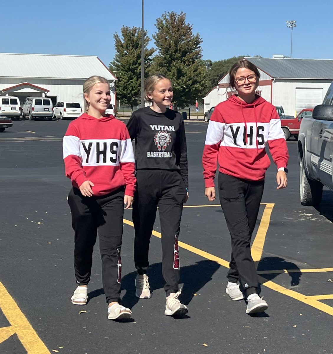 Sophomores Halle Arlt, Lexi Engel and Addy Darling walking towards the school on the freshly resurfaced parking lot. The resurfacing of the parking lot helped with safety concerns for students.