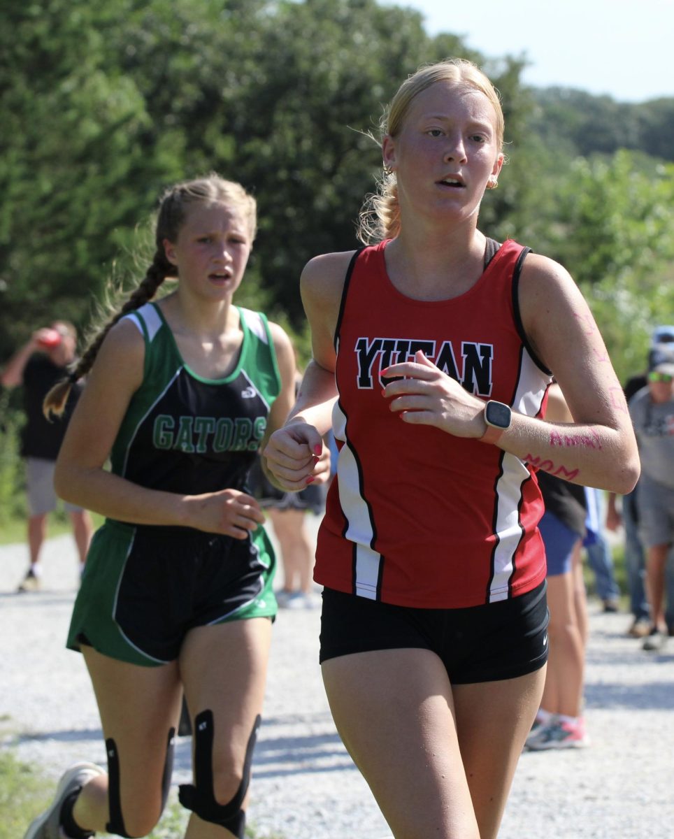 Junior Madi Ledden passes her competitor. Ledden has been running cross country since she was in seventh grade.