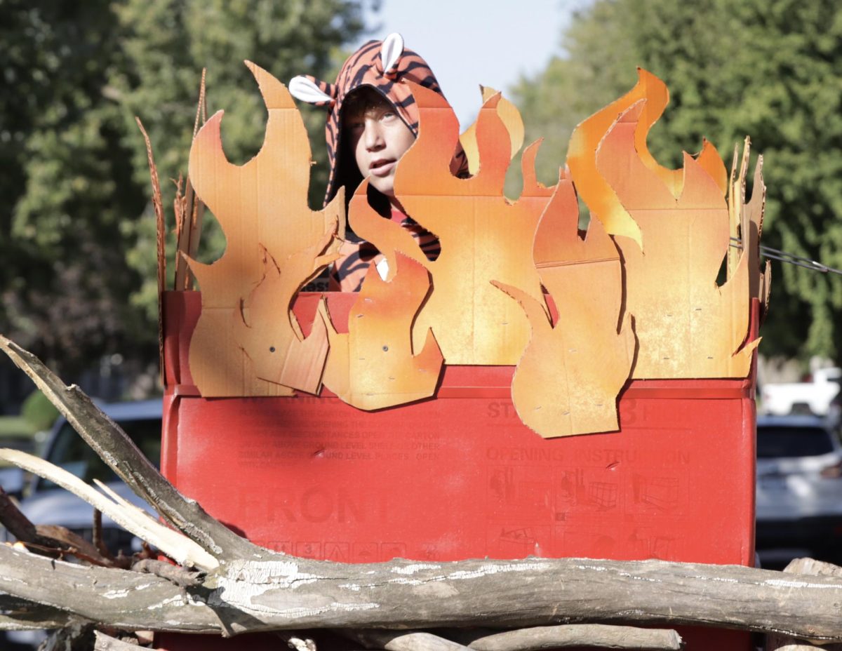 Eighth grader Wyatt Ringer acts like a tiger on their class float themed “Burn the Tigers.” The eighth graders placed second in the 2024 float contest. “There was this grandma that was growling at me,” Ringer said. “So I roared back.”