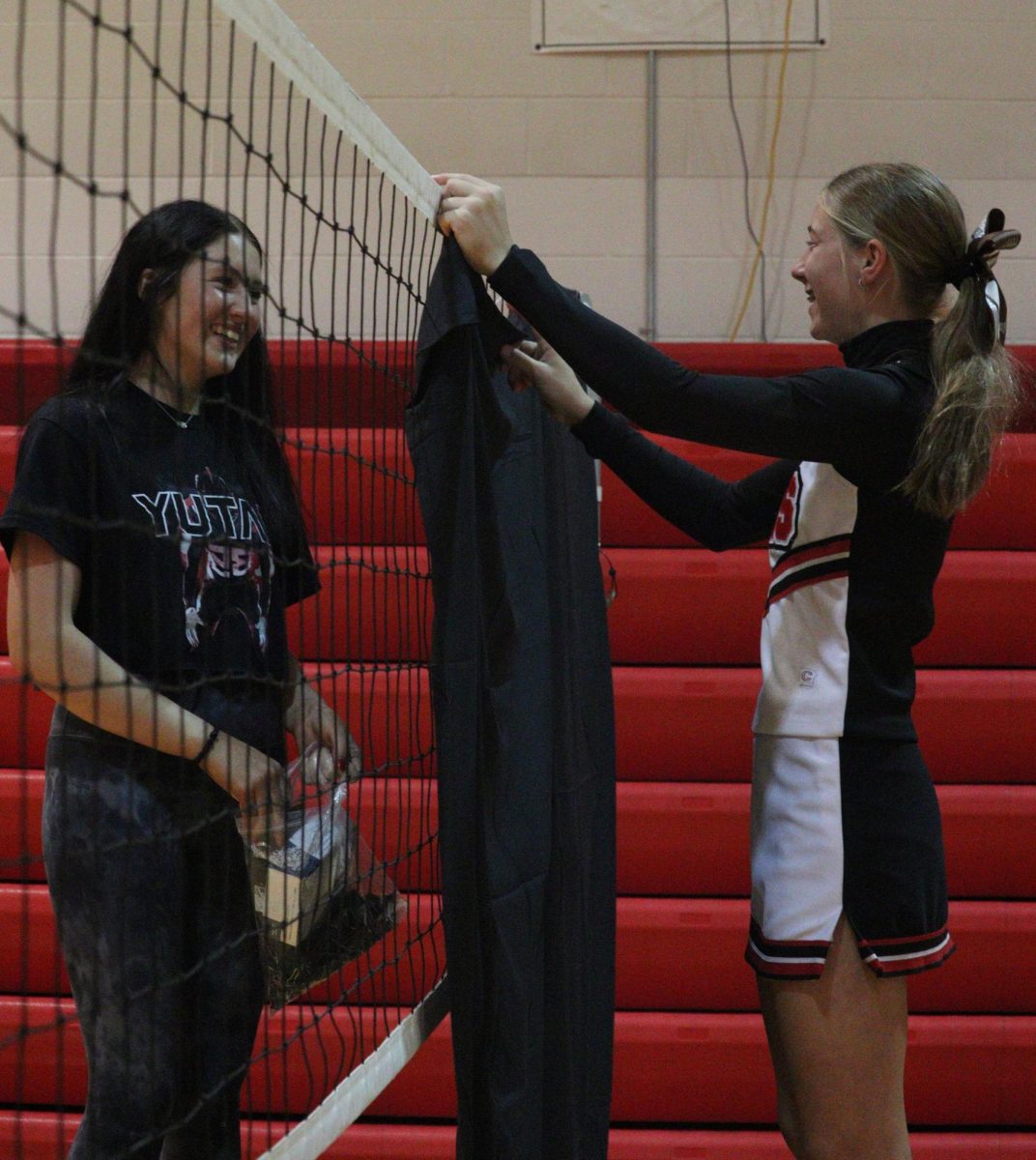 Senior Loganne Barta and sophomore Emmy Tederman set up a black tarp for the homecoming dance. The student council members stayed after school to decorate for the homecoming dance. “Helping set up for homecoming was a fun way to connect with people while setting up for the dance,” Tederman said.