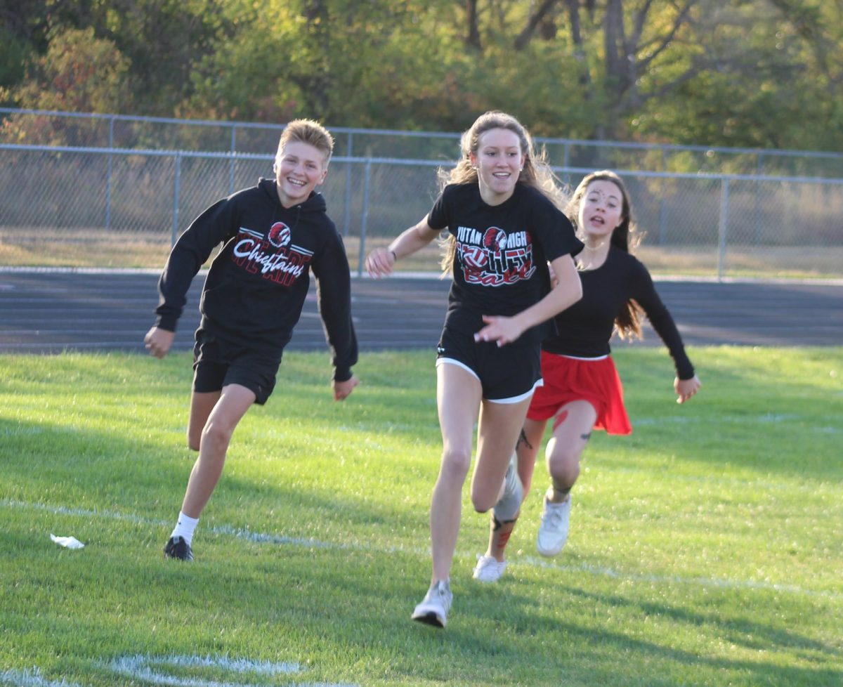 Freshman Cash Goeden and Jade Lawson sprint to tag Emmy Ray during freeze tag. Freeze tag was the freshmen's first activity of the day.