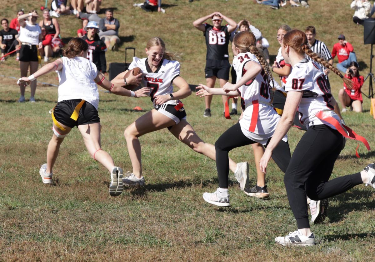 During the powderpuff football game, junior Allison Kirchmann tries to pull the flag off senior Gabi Tederman while seniors Alexis and Aubrie Pehrson try to protect her. The juniors beat the seniors in the game with a score of 12-0.  “It was just a fun time to bond with our grade and playing was fun, even though it didn't go how we wanted it to,” Tederman said. “It was just a friendly little competition.”