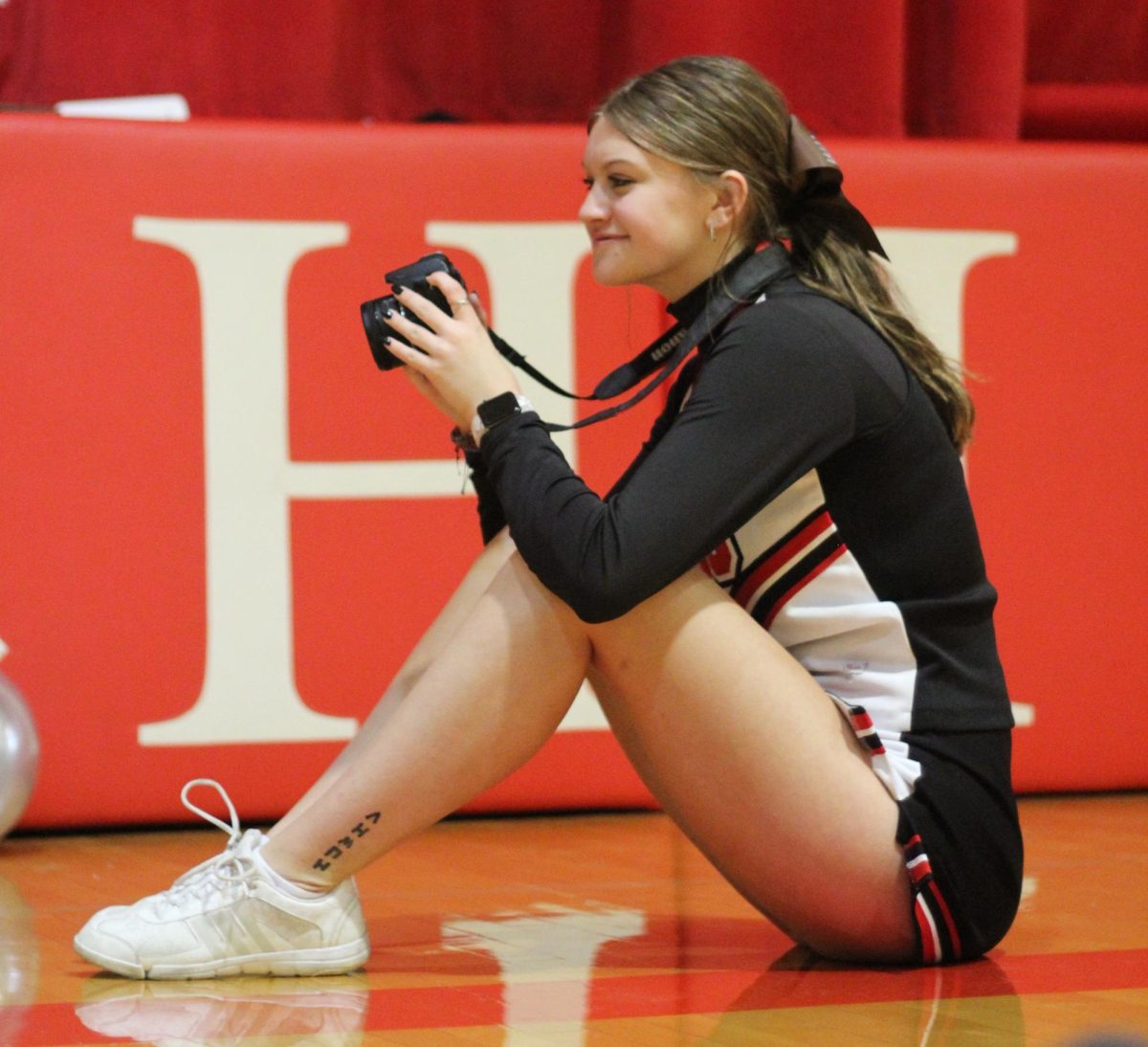  Senior Libby Winn grins while taking pictures of students decorating for the homecoming dance. Each journalism student is required to take pictures of at least two different homecoming events. “I’ve always chosen to take pictures at decorating because it’s a tradition student council does after school, and I really enjoy watching the dance get put together,” Winn said.