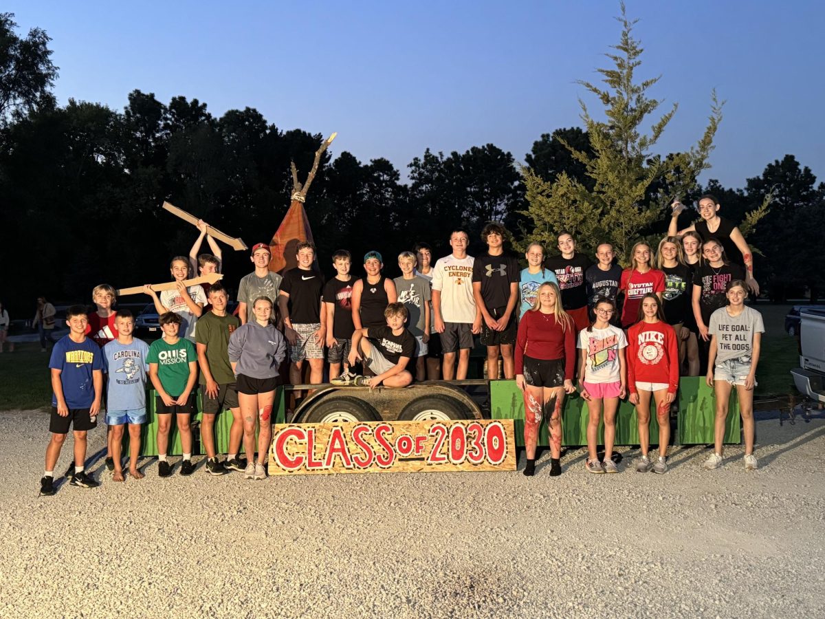 The seventh graders pose next to their finished float. This year more than half of the seventh graders showed up to the Wackers' house for the float decorating.