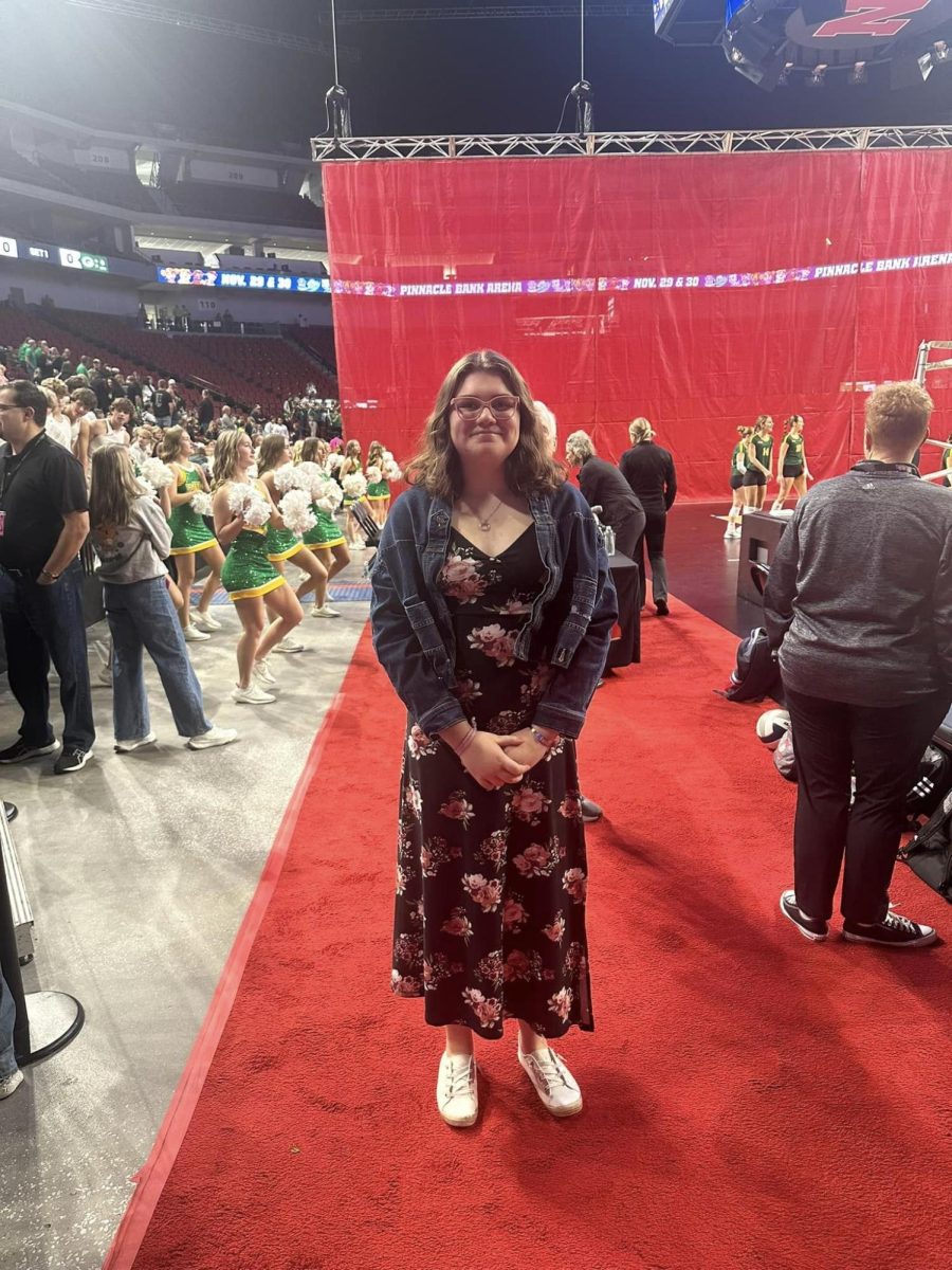 Junior Bella Sliva poses for a picture before singing the national anthem at the Pinnacle Bank Area. Sliva was selected from over 285 students at the state level.