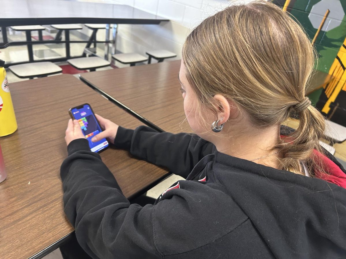 Junior Addi Smith locks into Block Blast in an attempt to beat junior Delaney Shield's high score. Many students use lunch or passing period to play. 