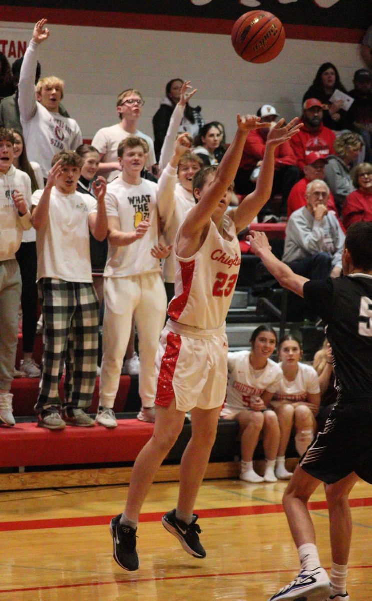 At a game against Elmwood-Murdock, senior Drew Krajicek shoots a three-pointer. This was Krajicek's first time playing in a varsity game.  