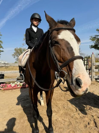 Seventh-grader Corryn Albers poses with her trainer's horse, Peaches. Albers has a strong bond with Peaches and enjoys riding him.